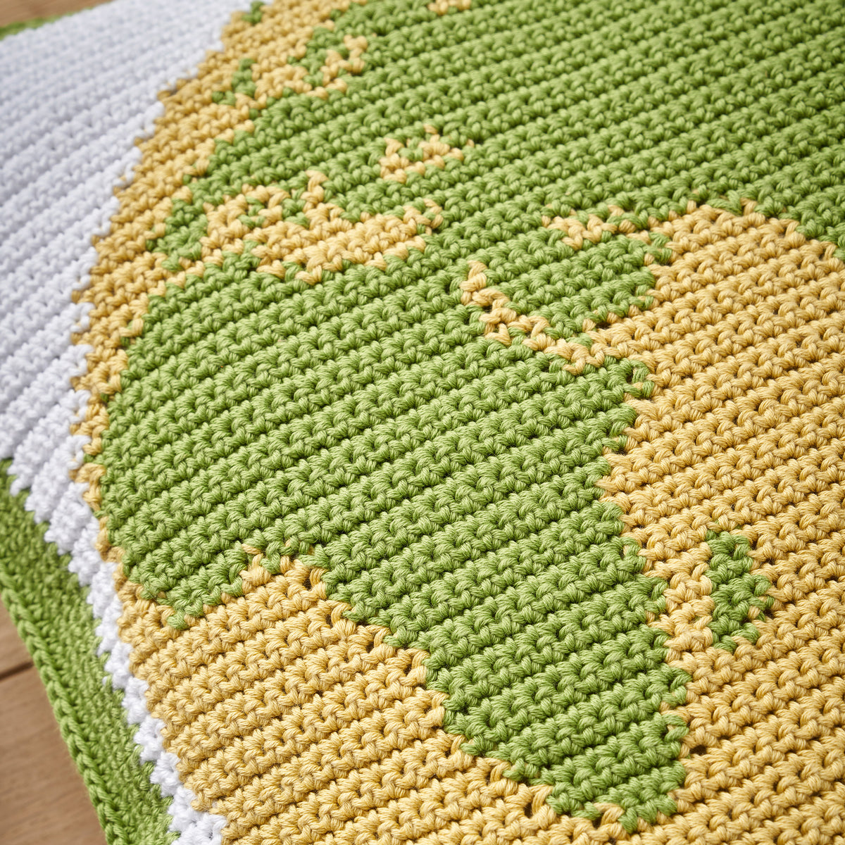 Close-up of a knitted fabric with green and yellow pattern