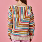 Colorful crochet sweater on a pink background