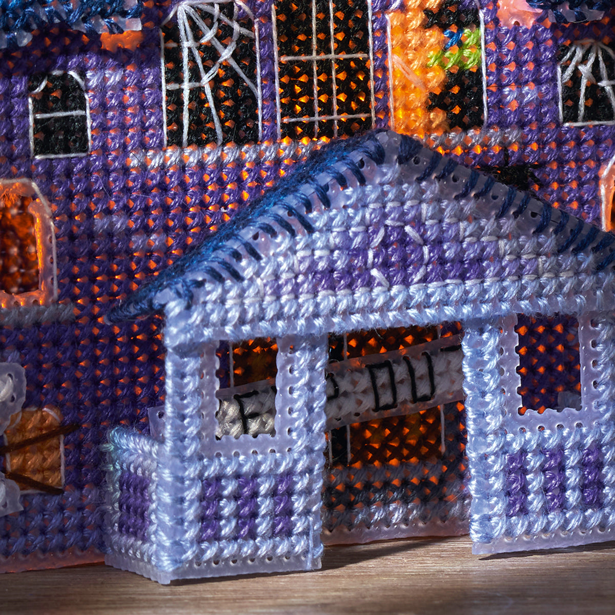Halloween-themed decorative cross stitch house with purple and orange colors.