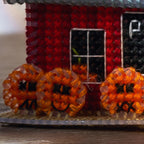 Decorative house with pumpkins in front, likely for Halloween.