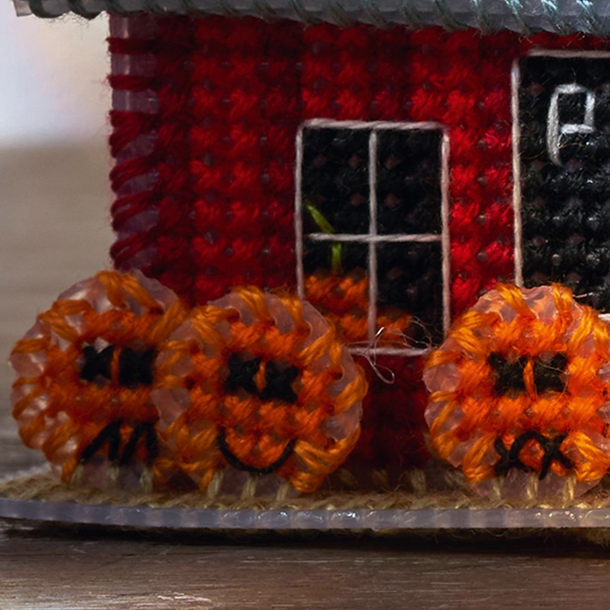 Decorative house with pumpkins in front, likely for Halloween.