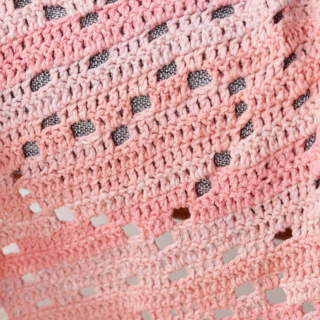 Close-up of a pink textured fabric with black and white speckles