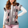 Woman wearing a patterned cardigan against a blue background