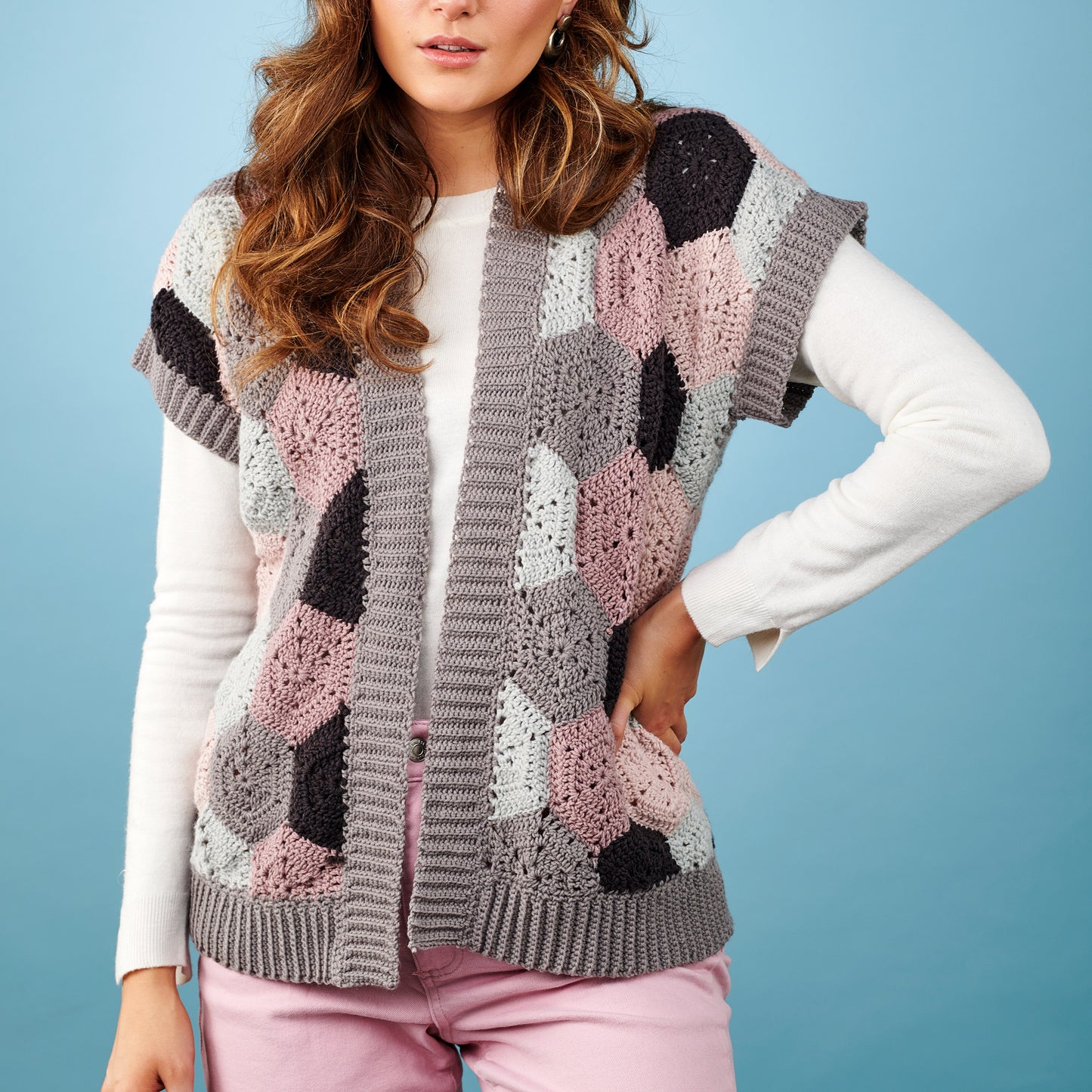 Woman wearing a patterned cardigan against a blue background