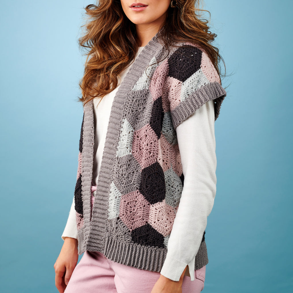 Woman wearing a patterned crochet vest against a blue background