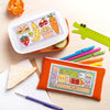 Cross-stitched pencil case and lunch box with food illustrations on a wooden surface.