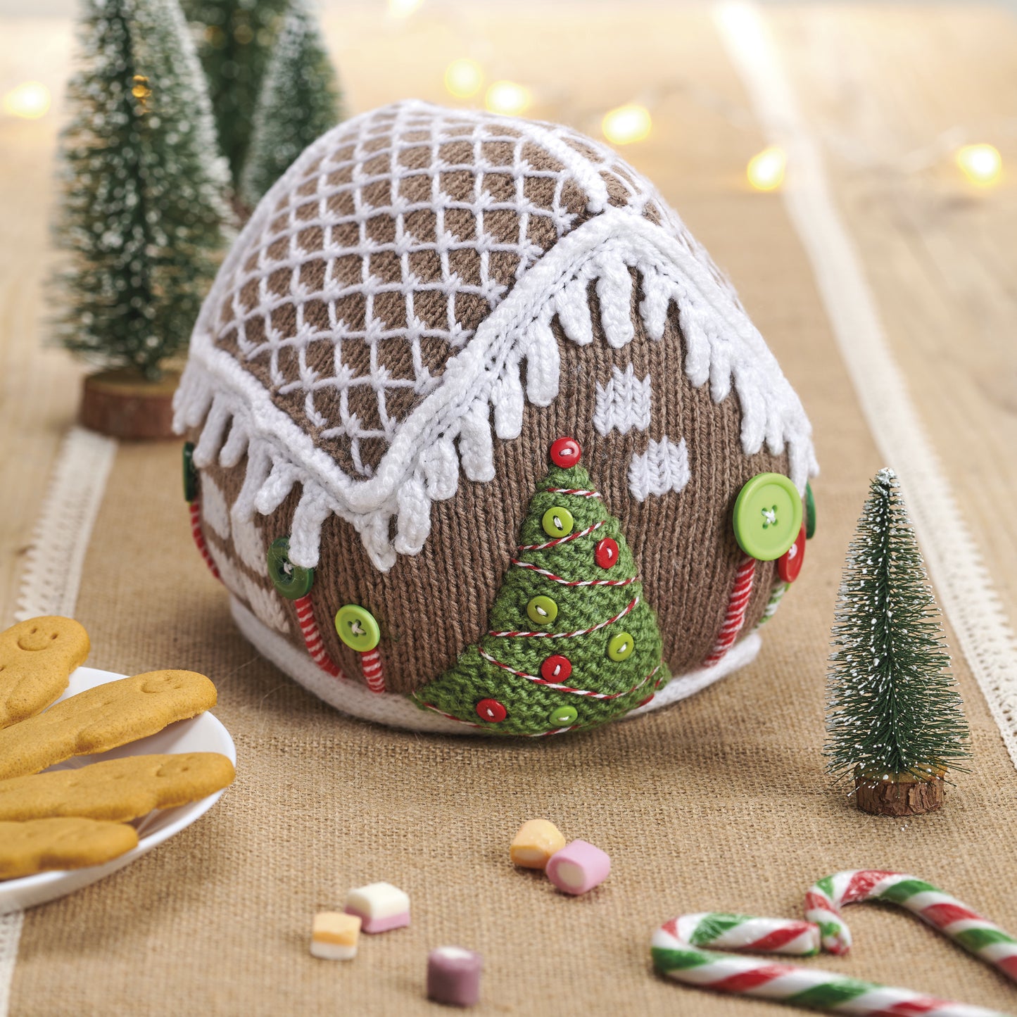 Decorative gingerbread house ball with candy decorations on a festive background