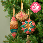 Decorative Christmas ornaments on a tree with a PDF pattern label.