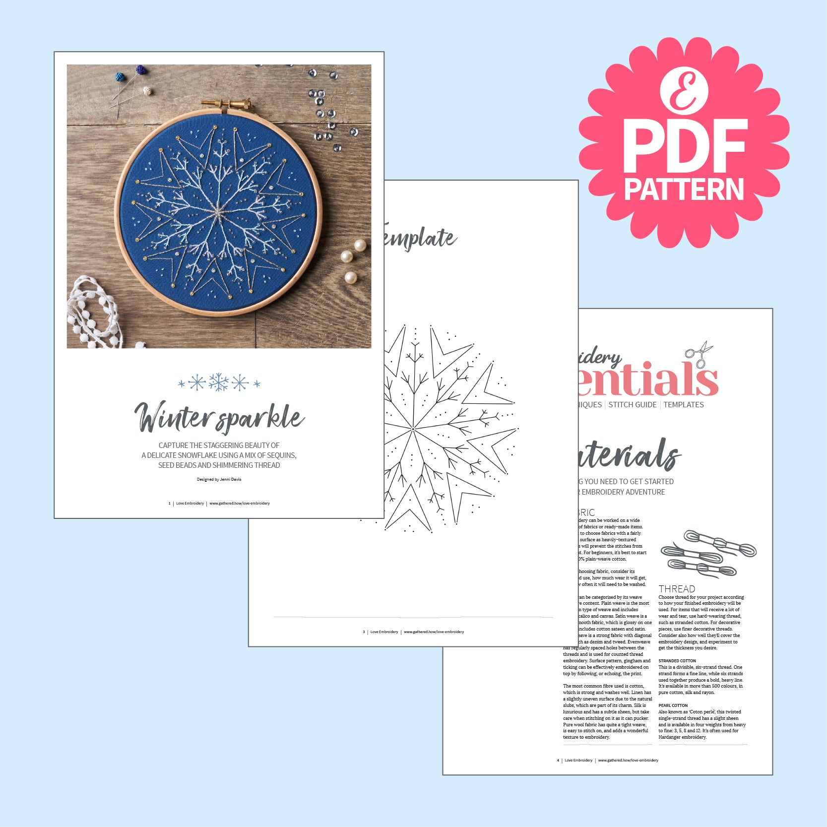 Embroidery hoop with blue design and related materials on a light blue background