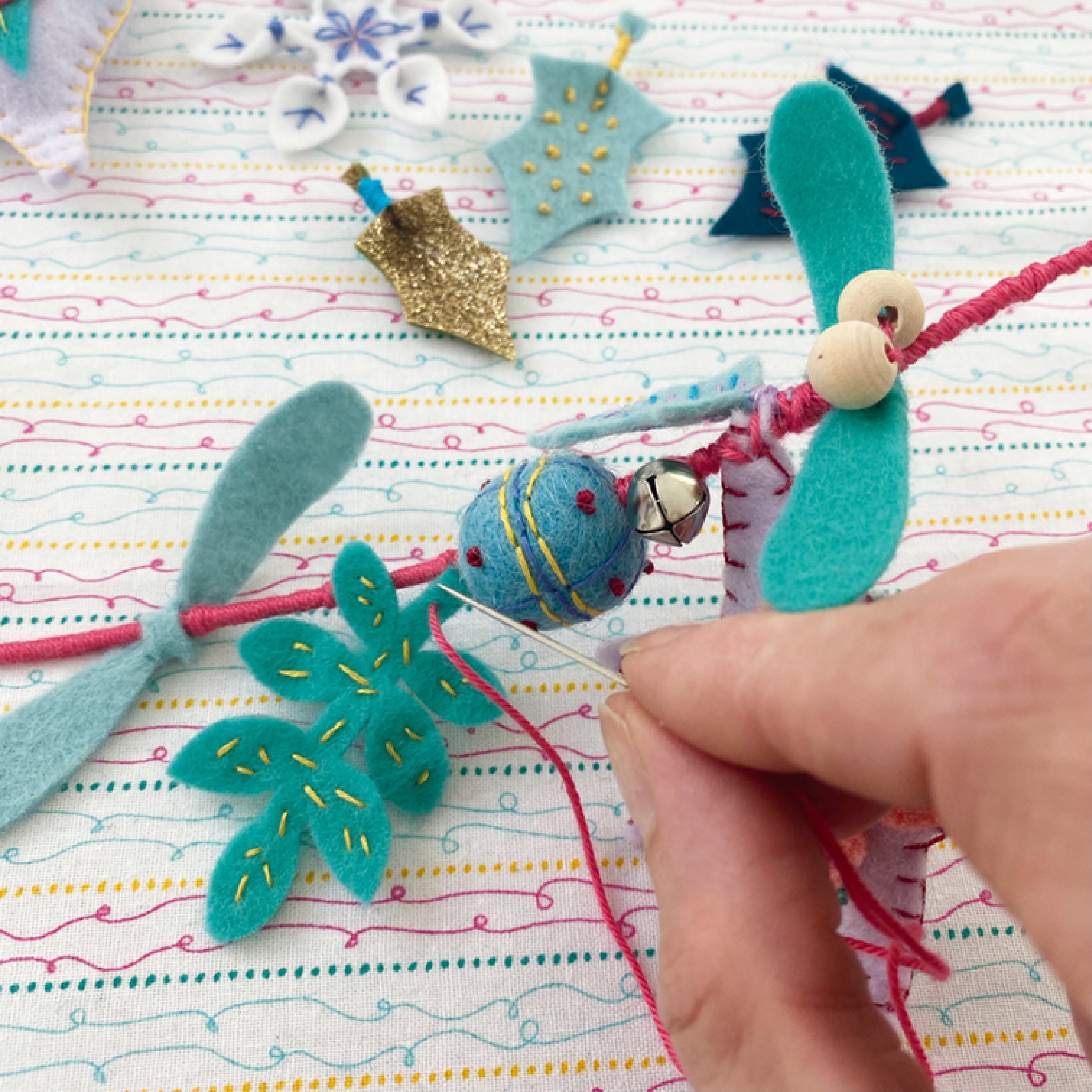 Handmade felt decorations on a colorful fabric background