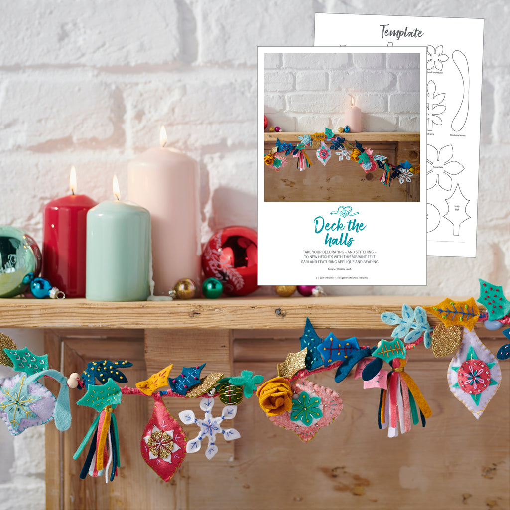 Decorative garland with colorful tassels on a wooden shelf with candles, and a template for the garland.