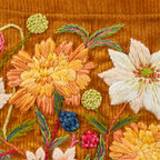 Close-up of embroidered flowers on a brown fabric background