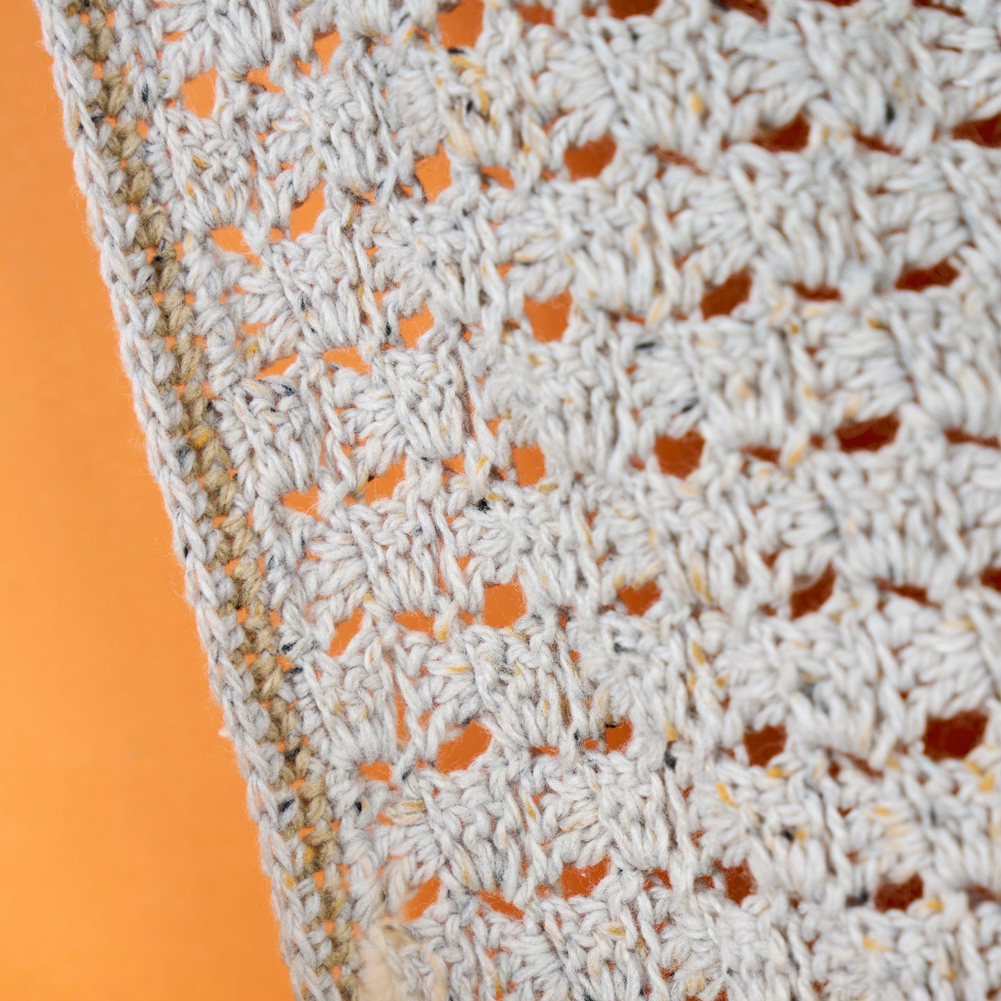 Close-up of a textured fabric with a pattern against an orange background