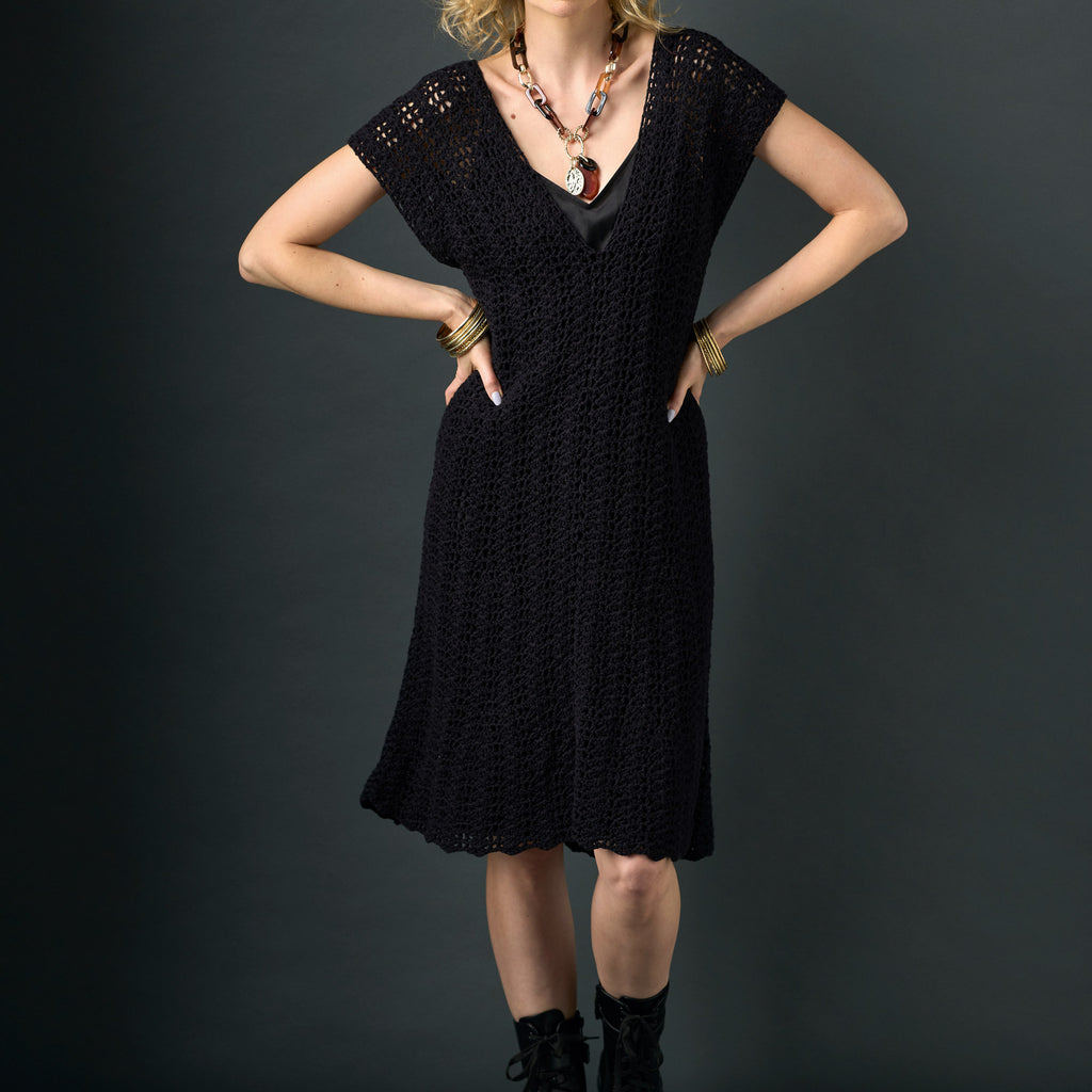 Woman wearing a black dress with a dark background