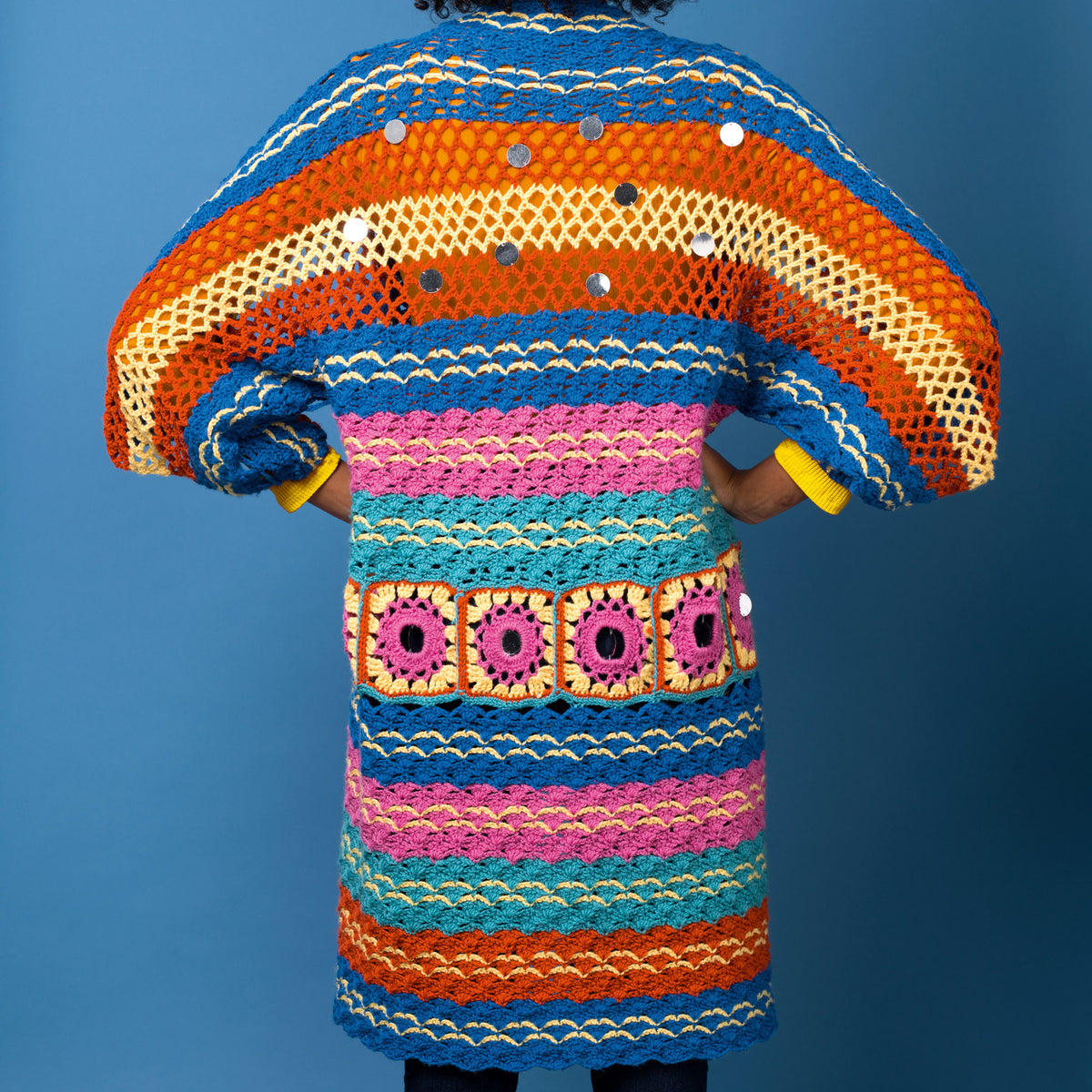 Colorful knitted dress with a pattern against a blue background