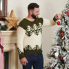 Man smiling while hanging a red ornament on a snowy Christmas tree. He wears a green and white sweater with a festive design. Cozy, holiday atmosphere.