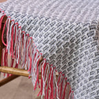 Gray and red woven blanket draped over a wooden chair