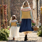 Two people walking together in a garden, both wearing patterned cardigans.