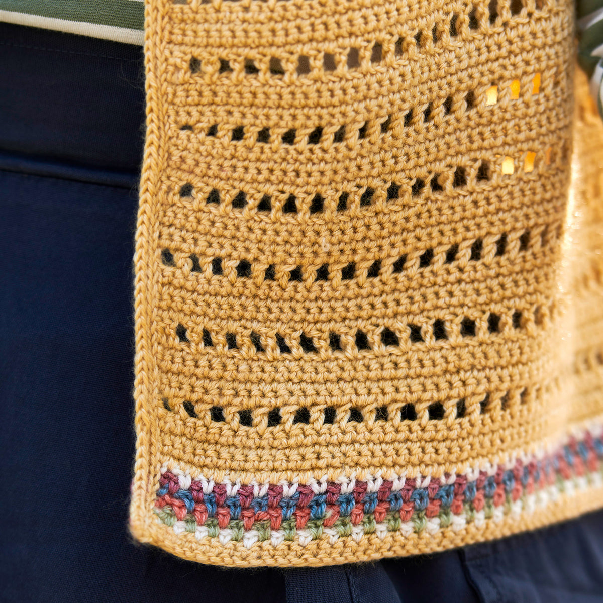 Close-up of a woven bag with a textured pattern and colorful trim.