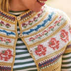 Person wearing a colorful crochet vest with floral patterns.