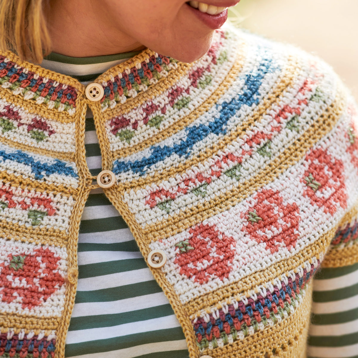 Person wearing a colorful crochet vest with floral patterns.