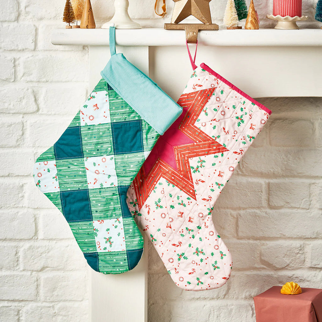 Two colorful quilted stockings hanging on a fireplace mantle.