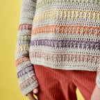 Colorful knitted sweater with a pattern against a yellow background