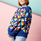 Person wearing a colorful patterned sweater against a pink and blue background