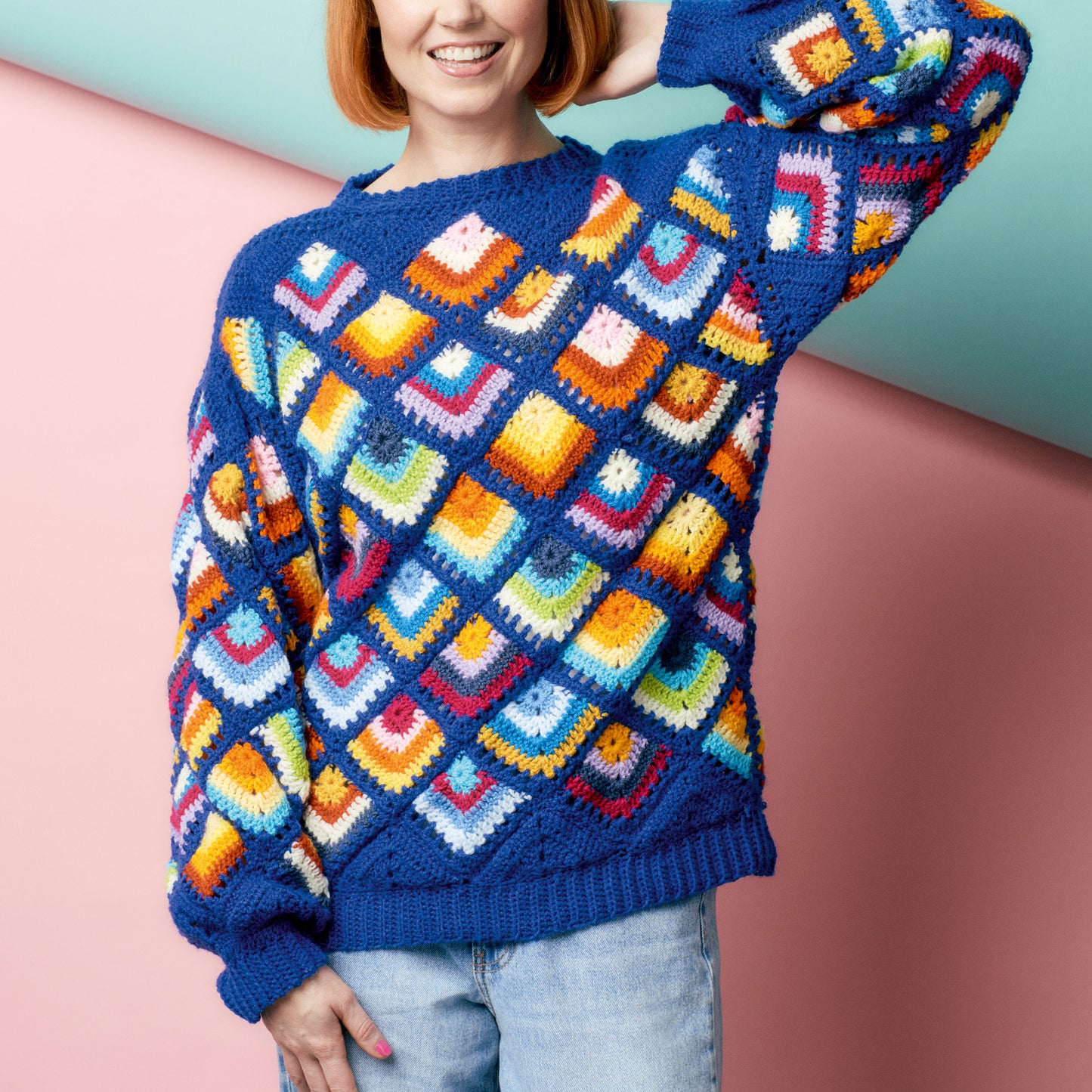 Person wearing a colorful patterned sweater against a pastel background