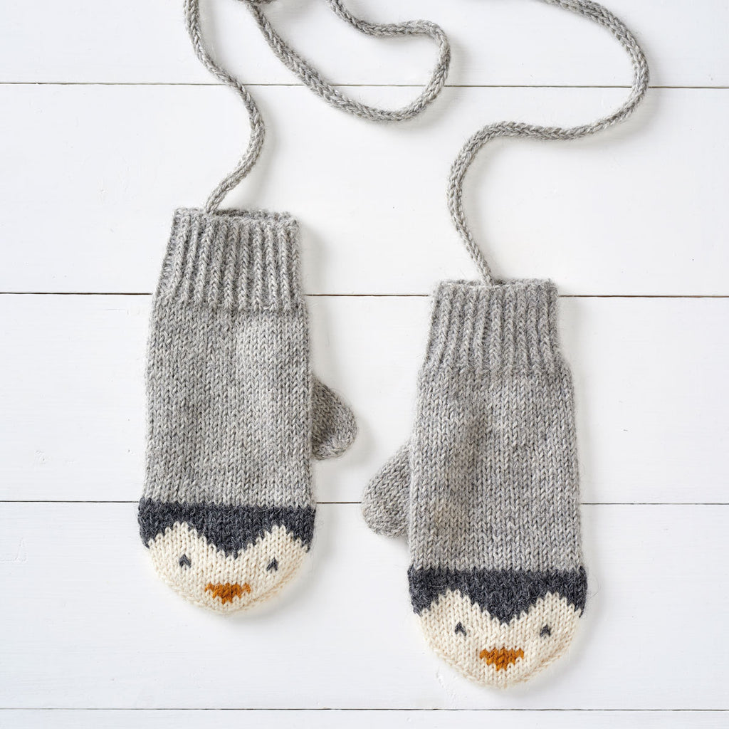 a pair of knitting mittens with a penguin design