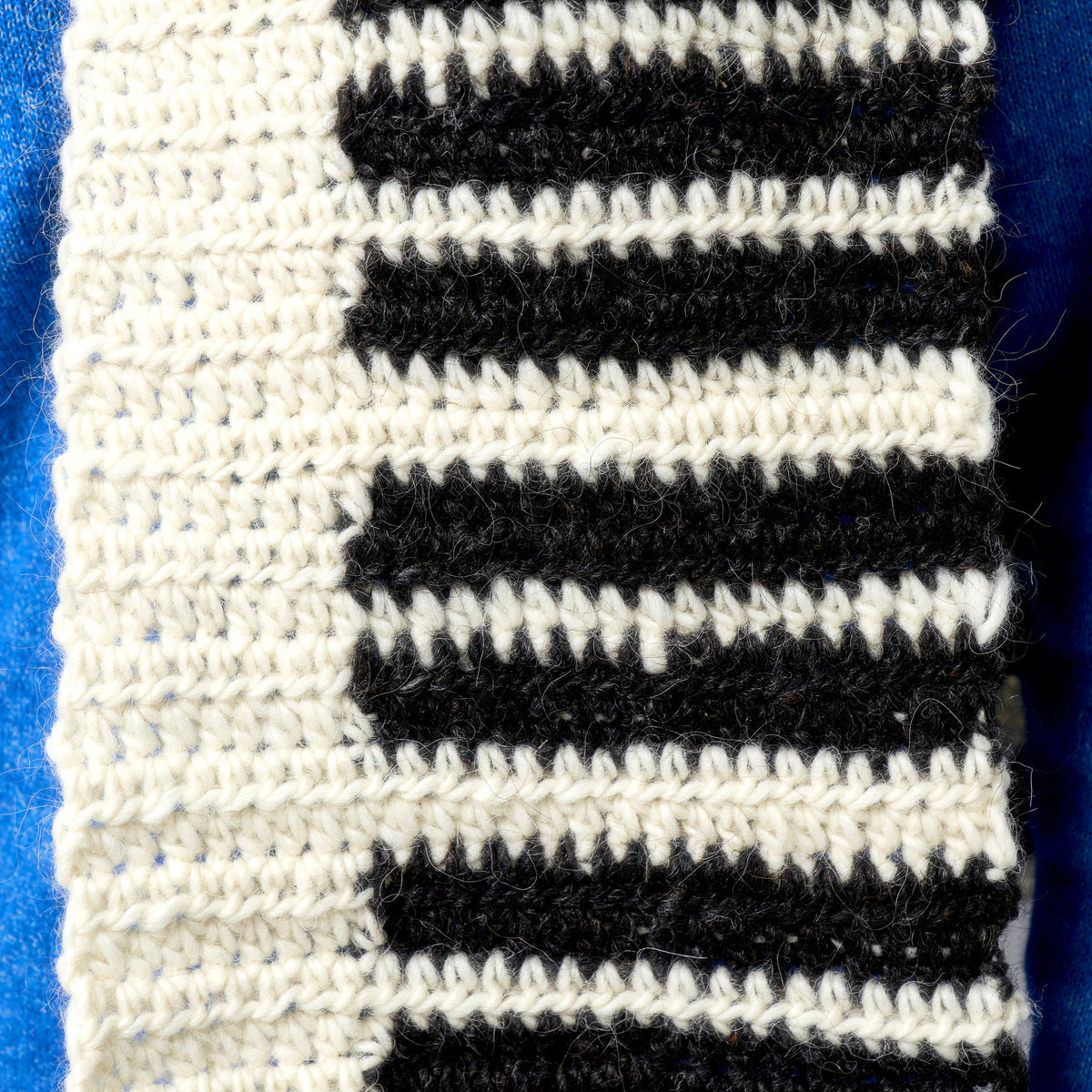 Close-up of black and white striped fabric on a blue background