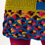 Colorful crocheted fabric with a geometric pattern on a white background