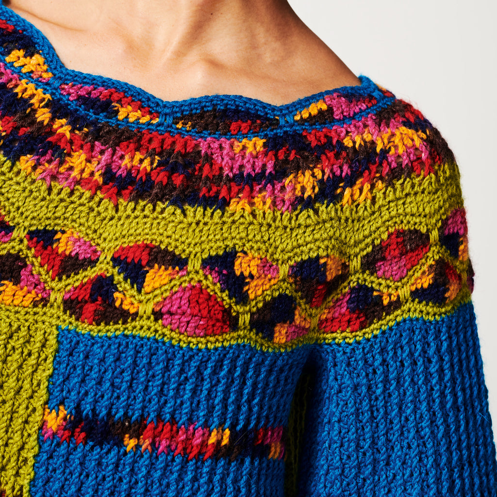 Colorful crochet garment with a geometric pattern on a plain background