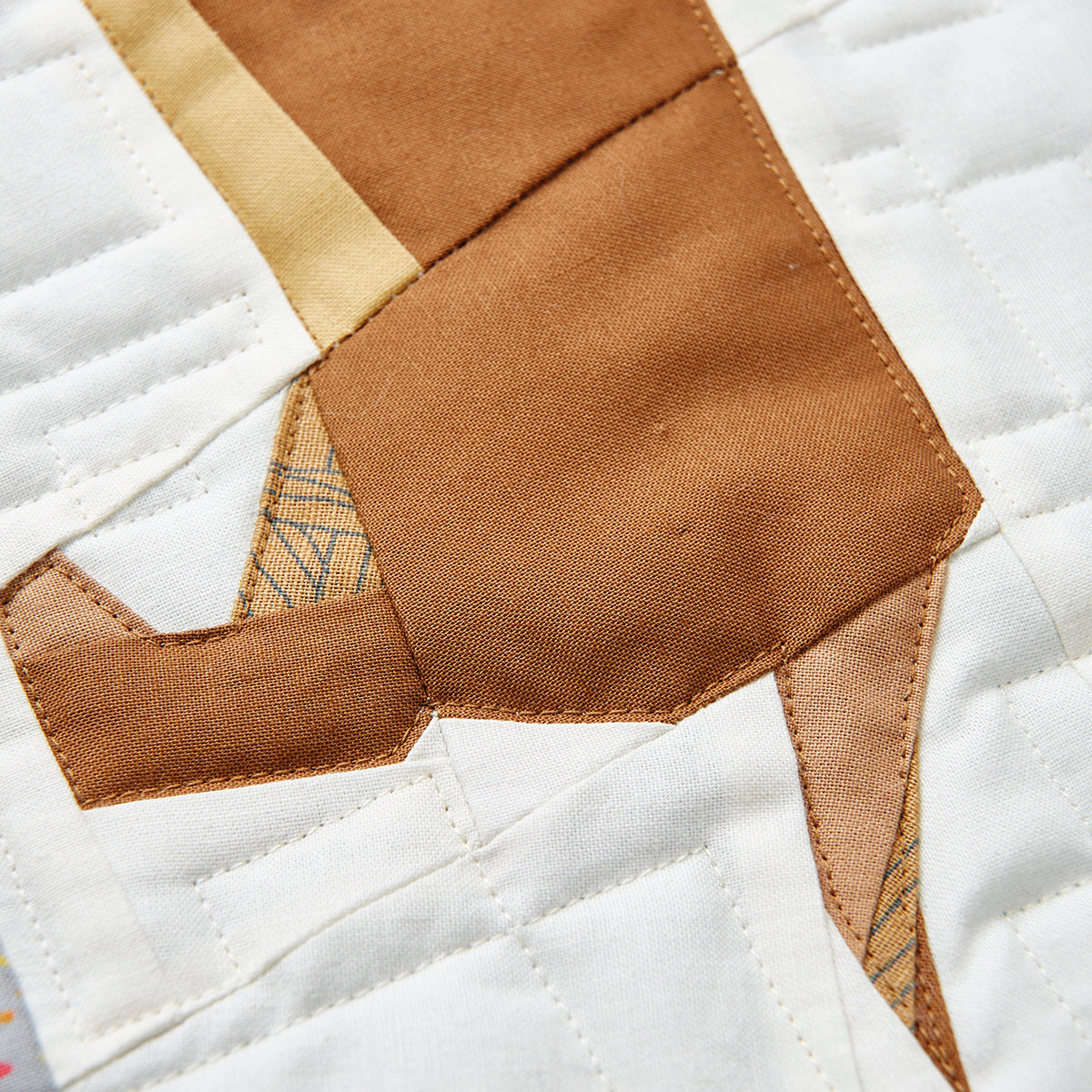 Close-up of a patchwork quilt with a dog face design.