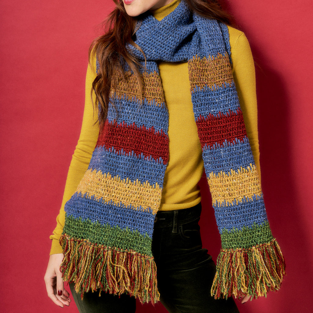 Person wearing a colorful striped scarf against a red background