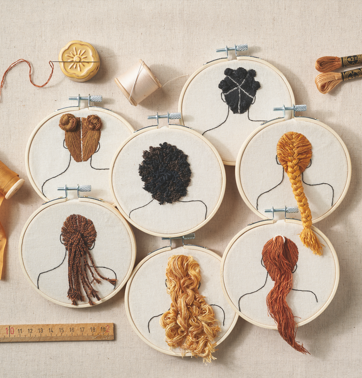 Embroidery hoops with yarn hair styles on a beige background