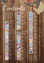 Wooden background with colorful quilt block images arranged in columns. Spools of thread and floral fabric add a cozy, creative atmosphere.
