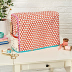 Fabric storage box with red and white pattern on a white surface with sewing supplies.