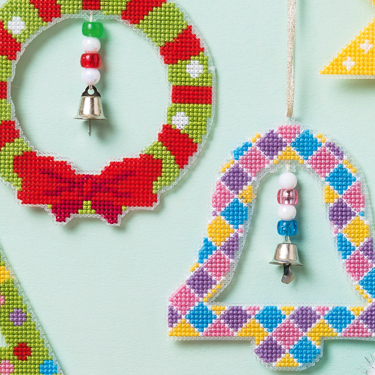 Colorful beaded heart-shaped ornaments with bells on a light blue background
