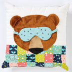 Bear-shaped pillow with a sleep mask on a white background