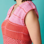 Person wearing a pink and red crocheted top against a teal background