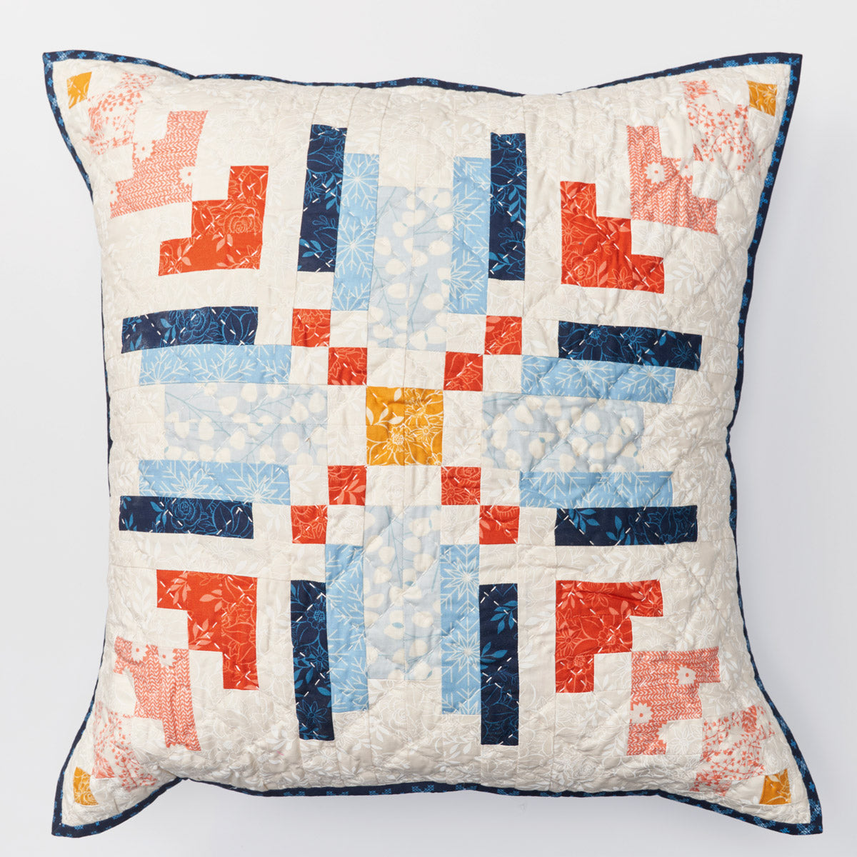Quilted pillow with geometric pattern on a white background