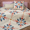 Quilt with geometric pattern on a bed with pillows