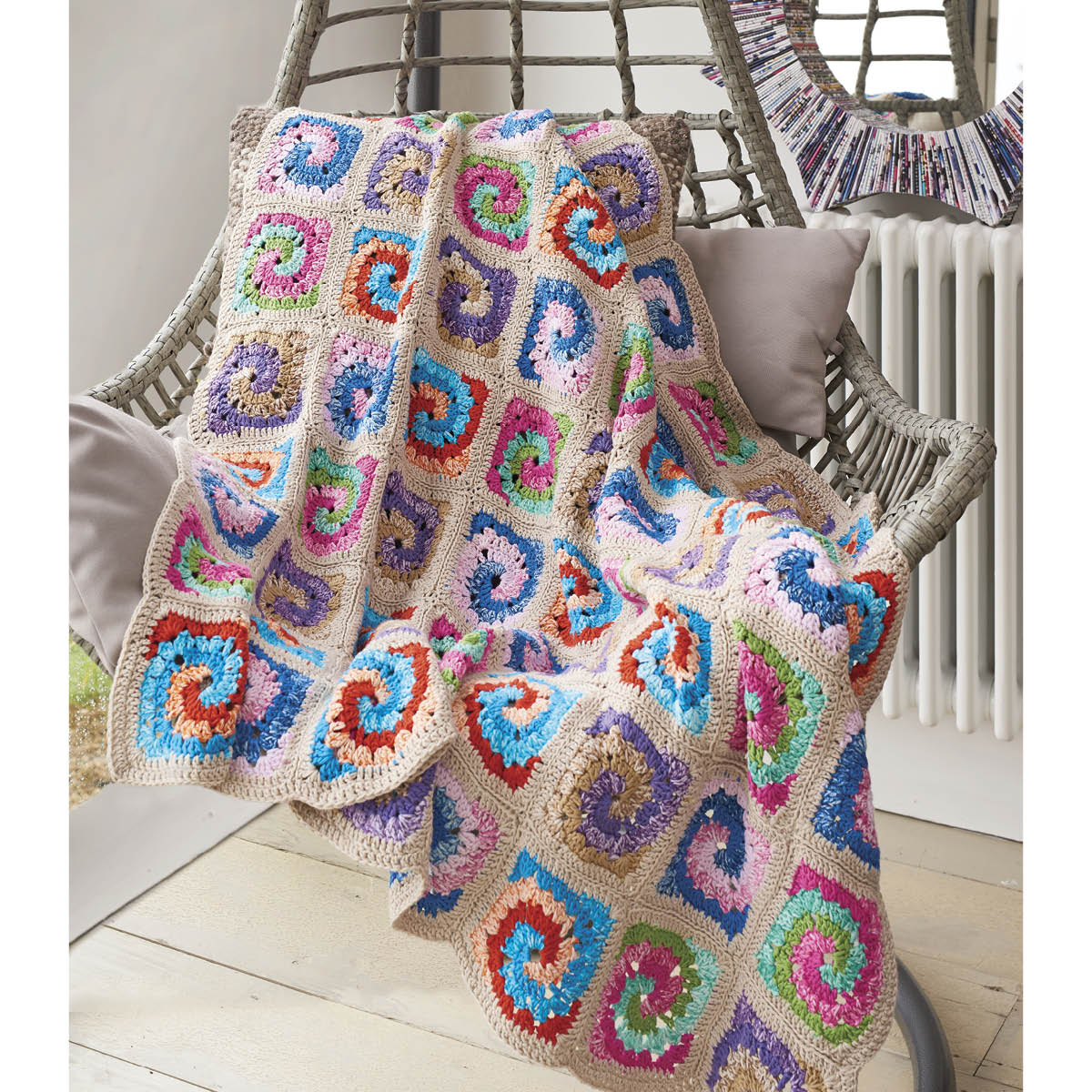 Colorful crocheted blanket draped over a chair with a neutral background