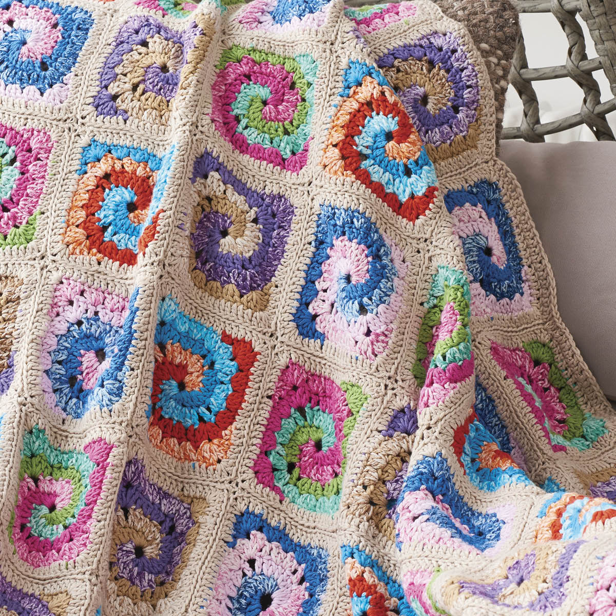 Colorful crocheted blanket with square patterns on a neutral background