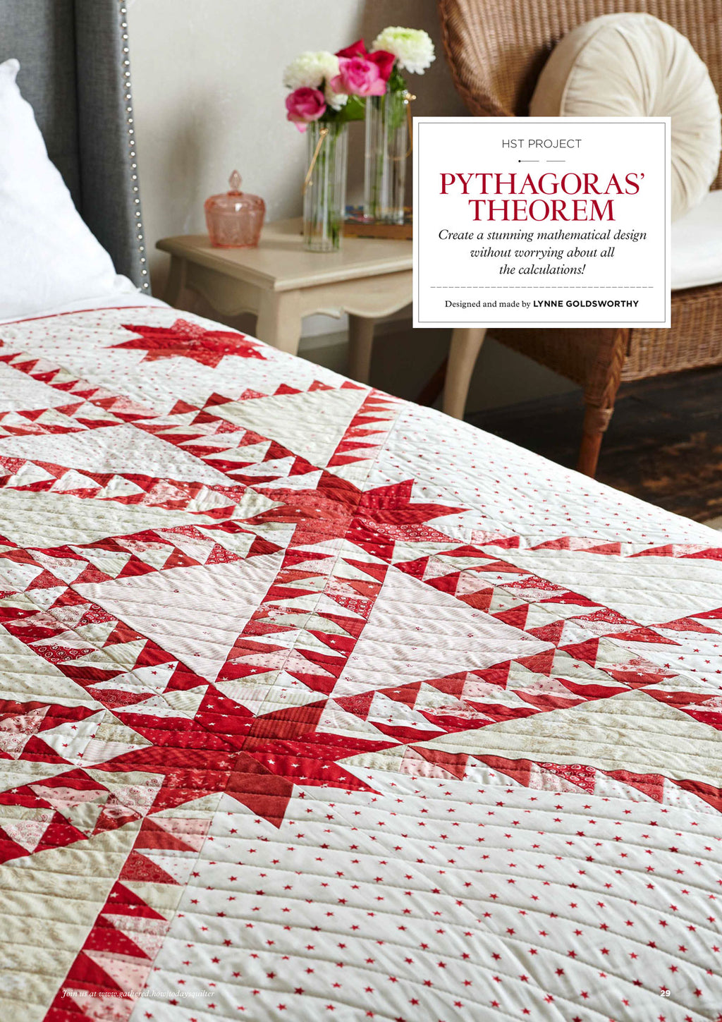 A red and white quilt with star and triangle patterns drapes over a bed. A bedside table with flowers and a candle is in the background, creating a cozy ambiance.