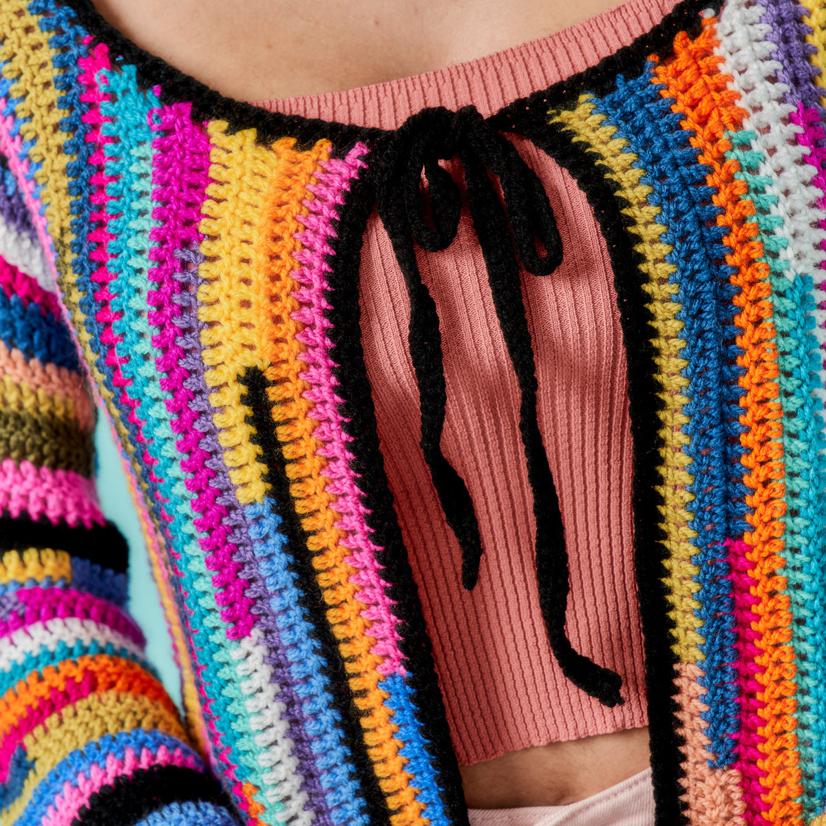 Colorful striped sweater with a pink ribbed knit top underneath