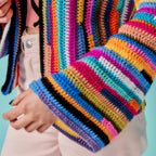 Colorful striped sweater worn by a person against a light blue background