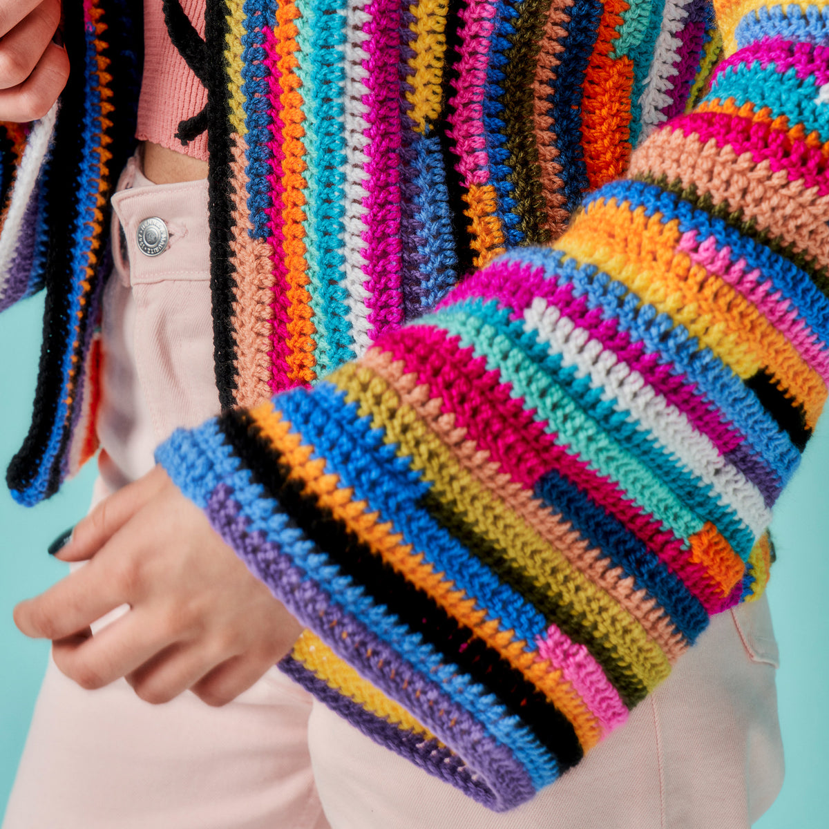 Colorful striped sweater worn by a person against a light blue background