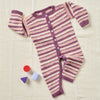 Striped baby romper with buttons on a textured surface